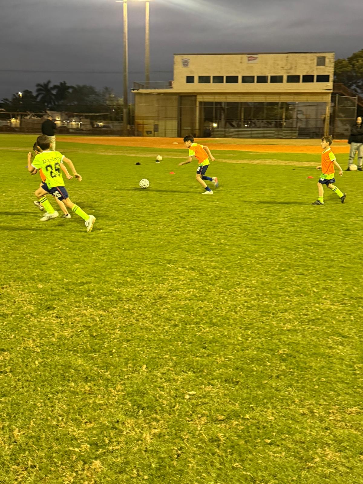 Kids playing evening soccer practice — community youth soccer Broward County